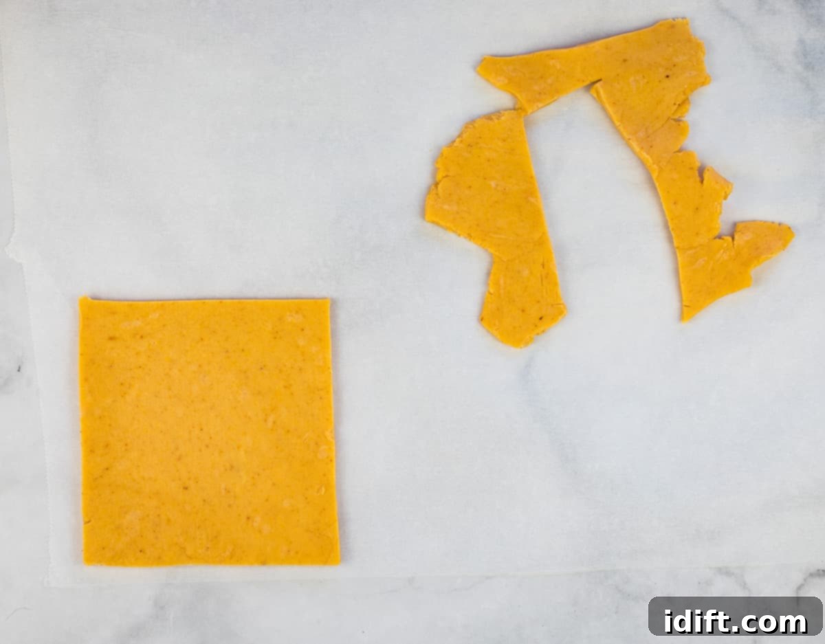 Cheez-It dough rolled out thinly on parchment paper and cut into large squares.