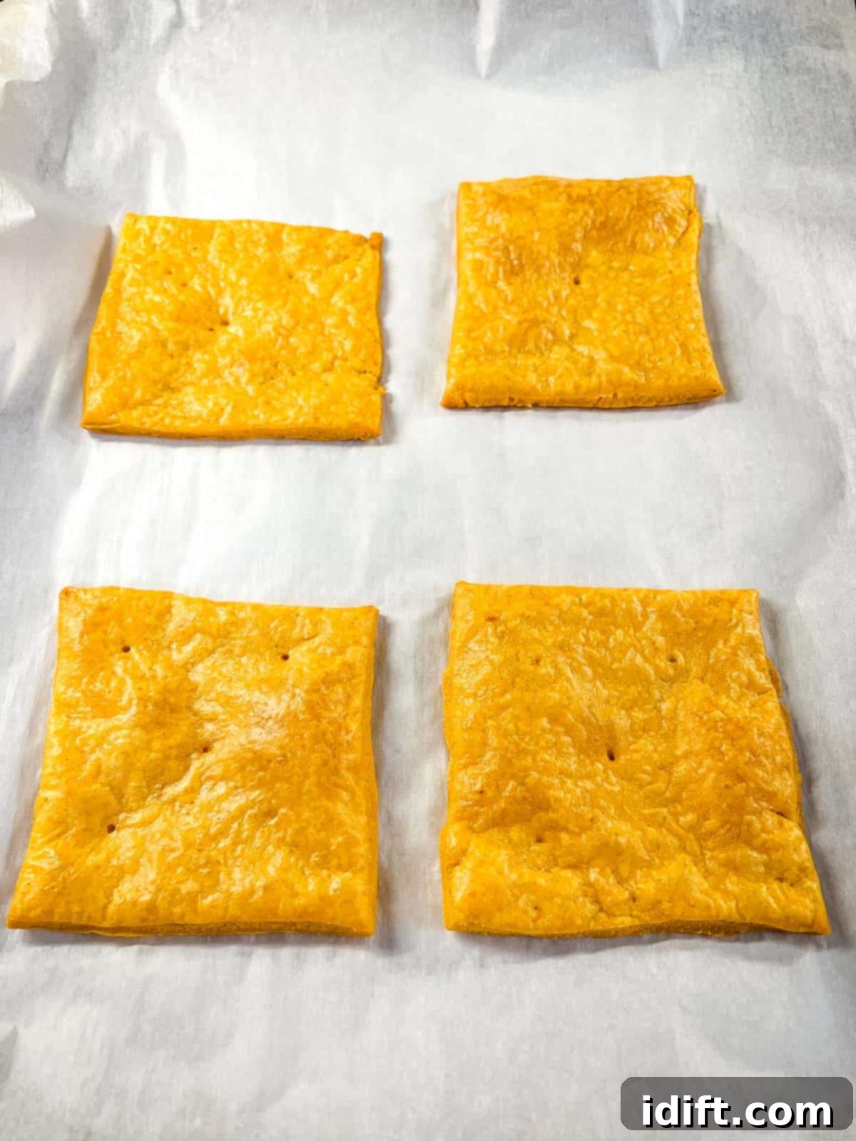 Golden-brown baked giant Cheez-It crackers cooling, ready to be topped.