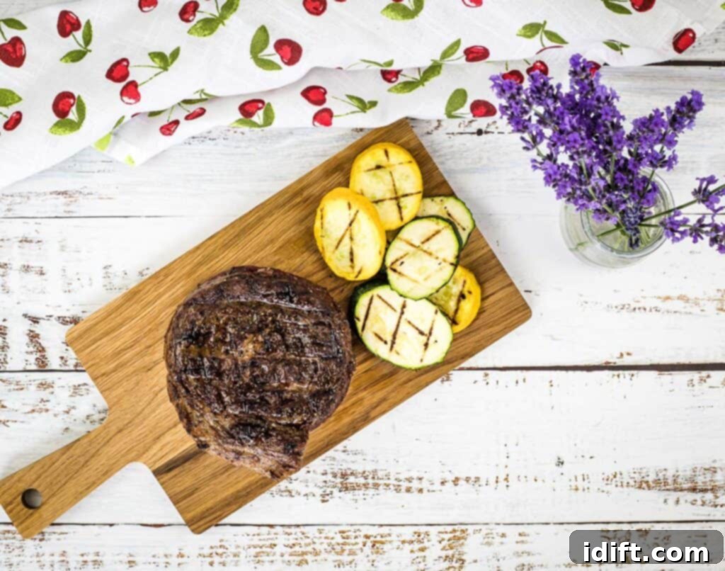 grilled ribeye cap steak on a board with veggies 