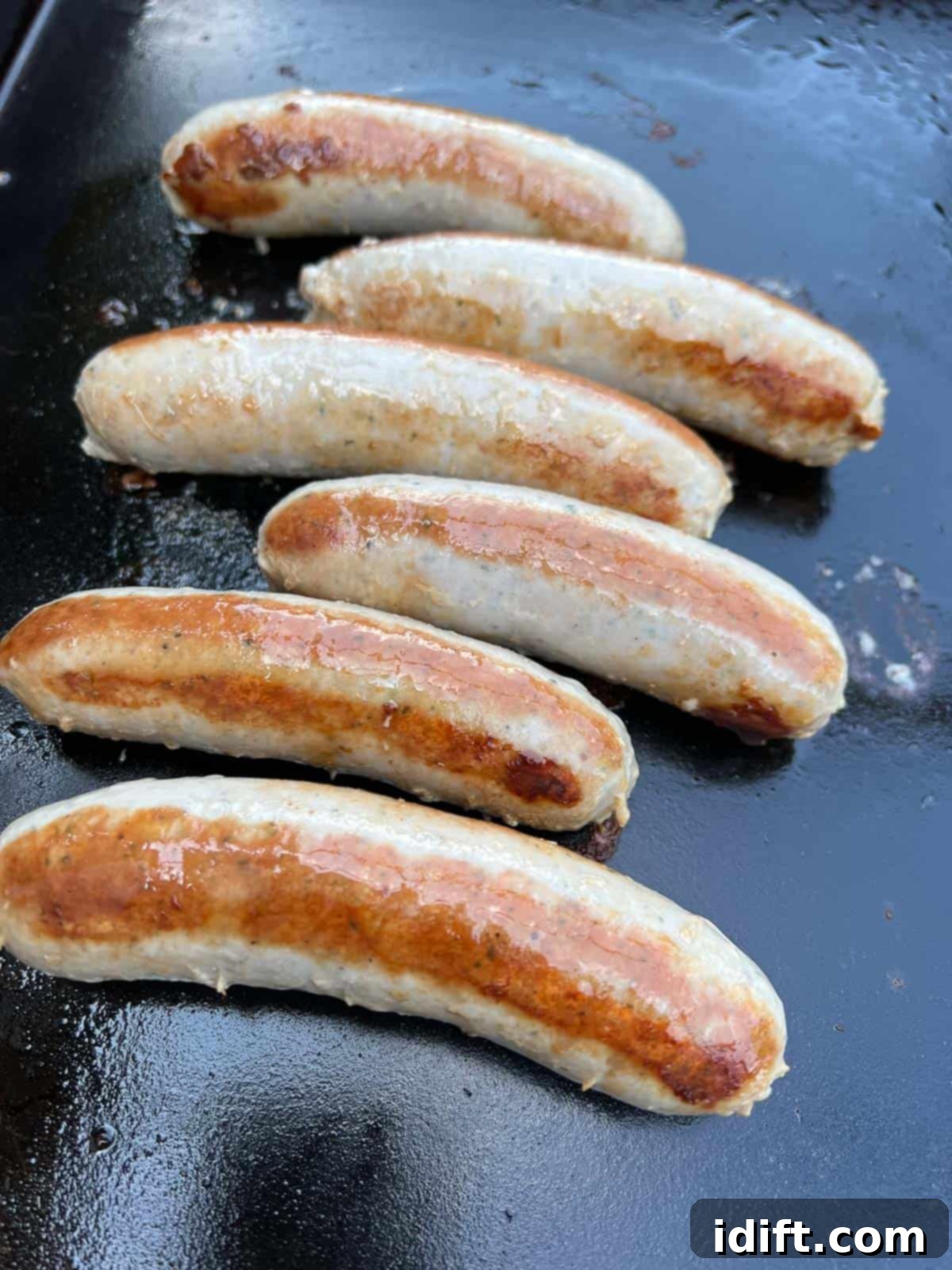 Perfectly cooked sausages with crispy skin on a Blackstone griddle after steaming