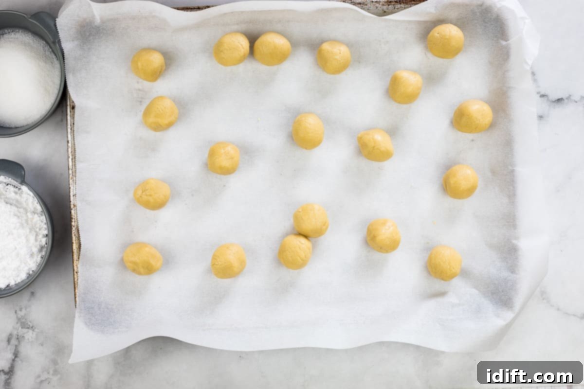 rolled balls of white chocolate crinkle cookie dough