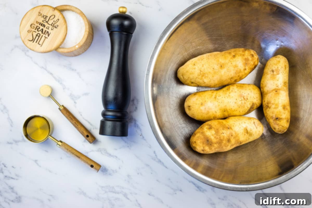 Potatoes tossed with oil, salt and pepper in a bowl.