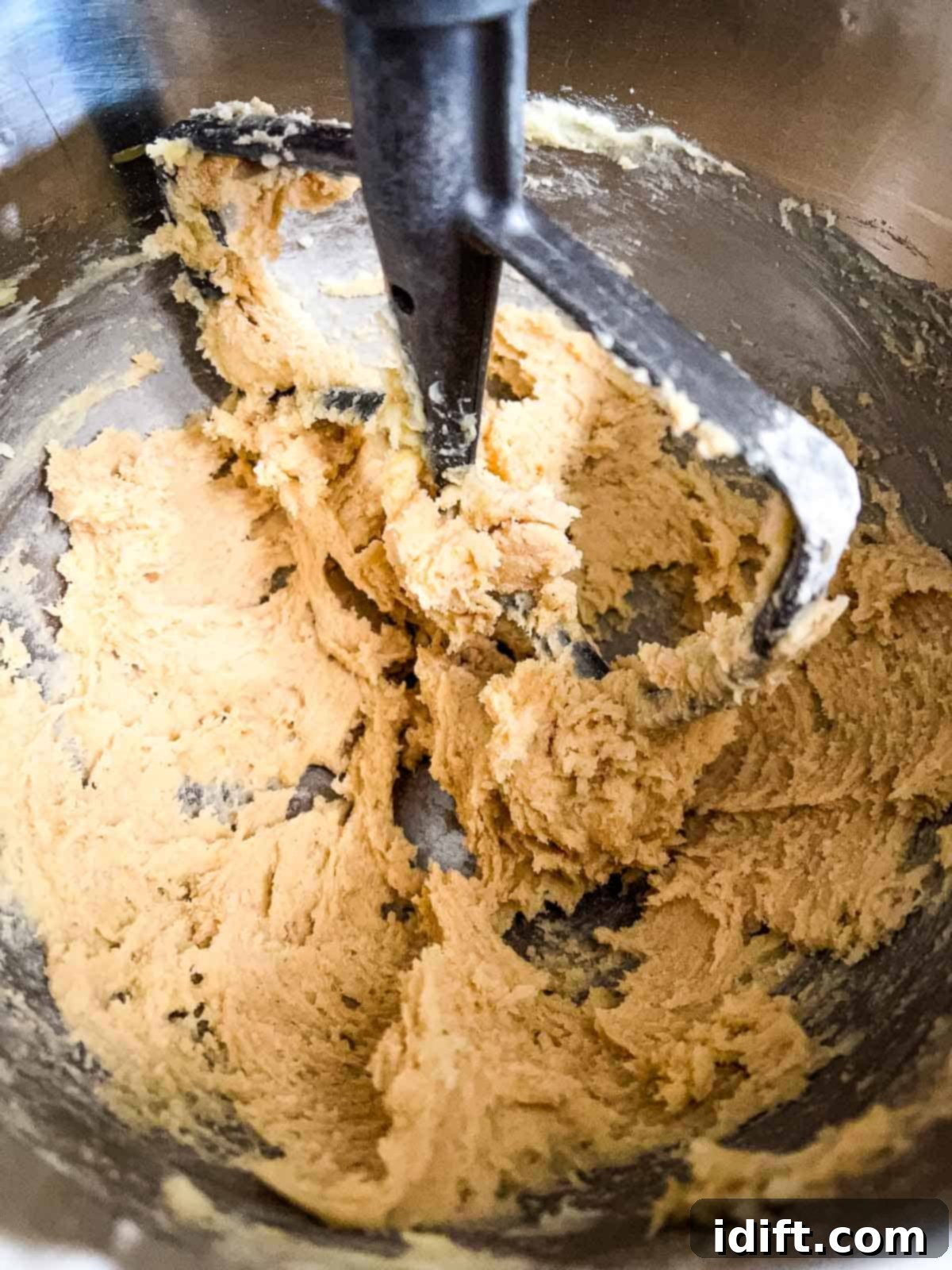 adding the flour to the cookie dough in a mixer