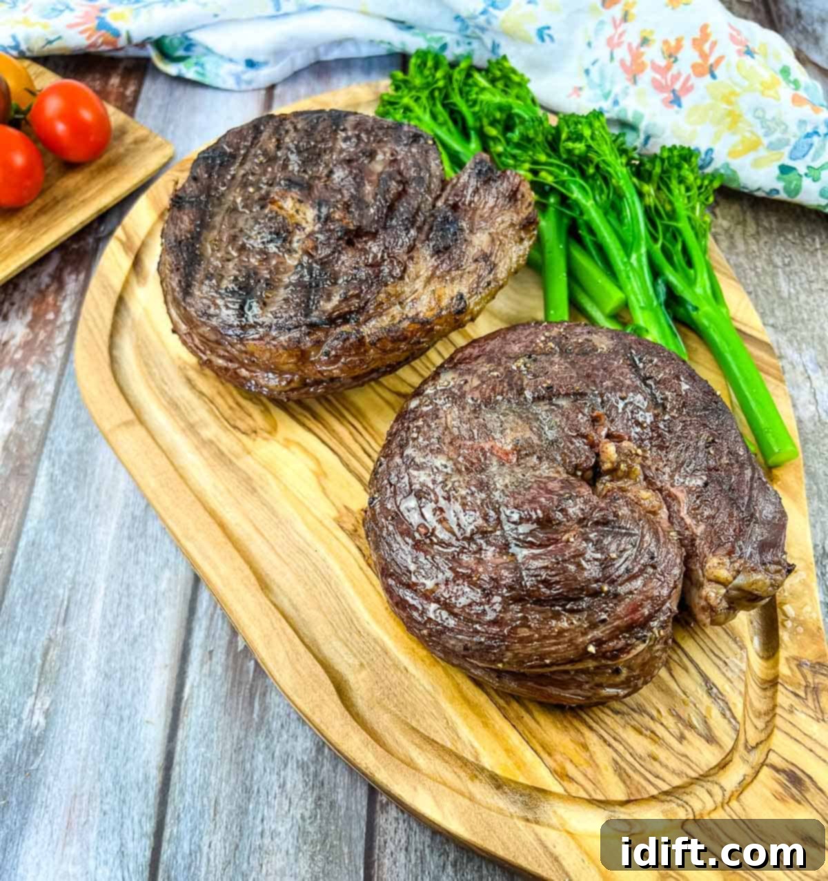 Smoked Ribeye Cap Steaks on a cutting board with broccolini, ready to be served.