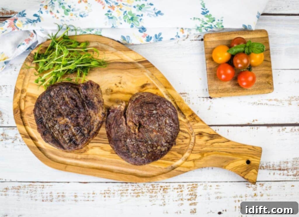Perfectly smoked ribeye cap steaks resting on a cutting board, showcasing their beautiful crust and juicy interior.