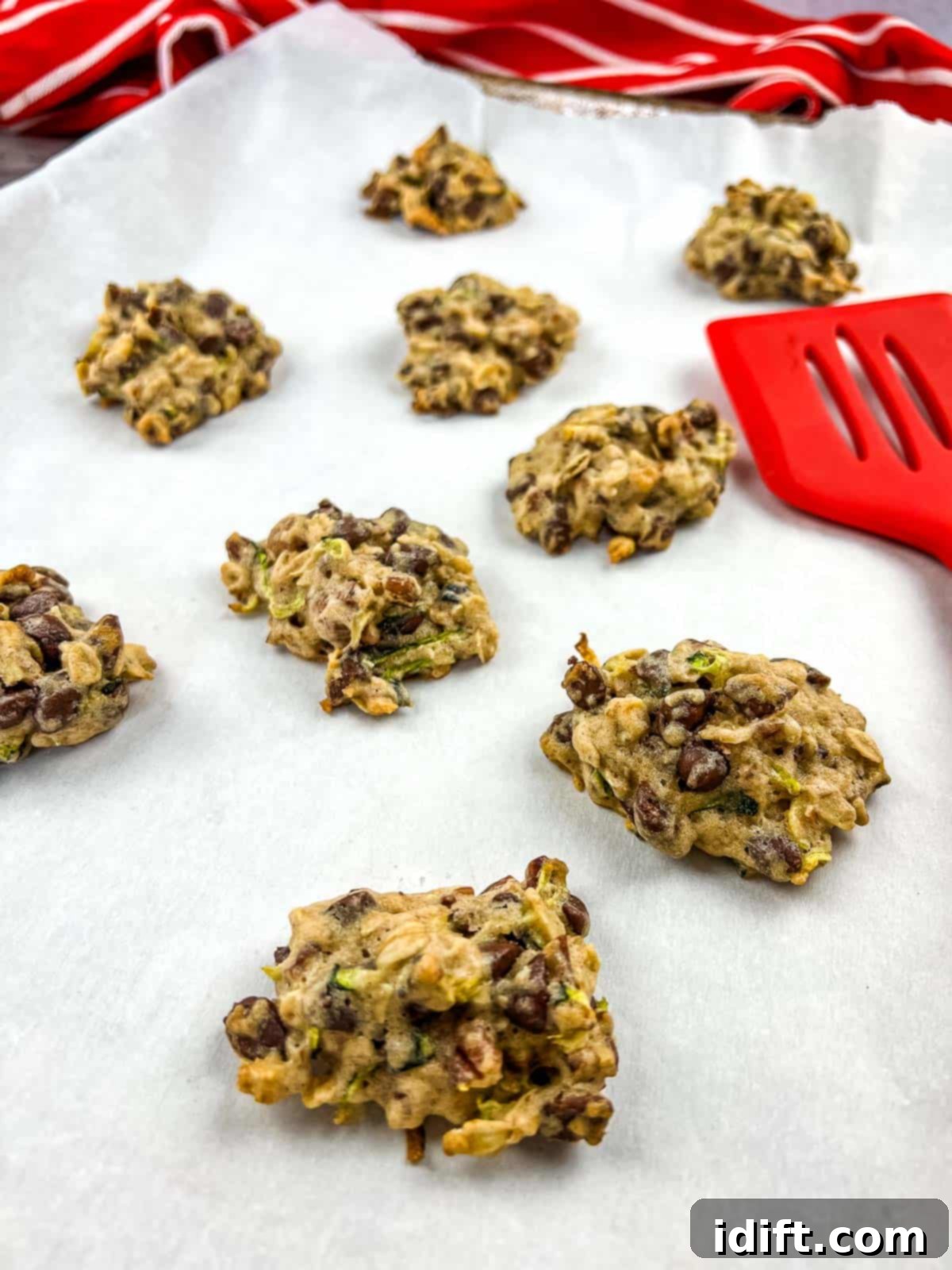 Delightful zucchini cookies with chocolate and pecans, freshly baked on a baking sheet, ready to be enjoyed.
