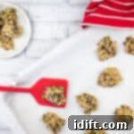 Zucchini Cookies with Chocolate & Pecans with Chocolate Chips and Oatmeal on a baking sheet with a red spatula.