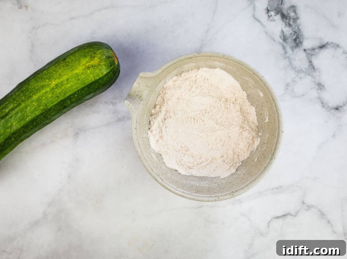 Hands mixing the dry ingredients together in a bowl for zucchini cookies.