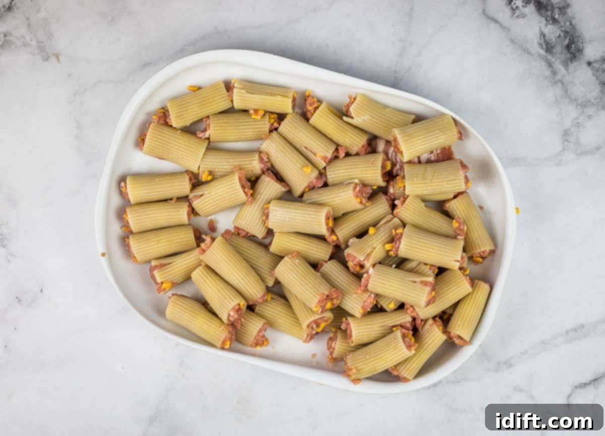 A collection of par-boiled rigatoni noodles, carefully stuffed with the rich, savory meat and cheese mixture.
