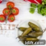 Ember-Kissed Jalapeños 4 Smoked jalapenos ready to eat, served on a white plate with a fork.