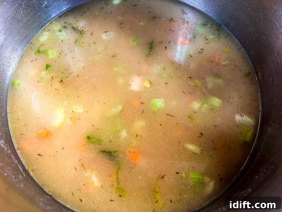 Pouring broth and milk into the pot with vegetables.