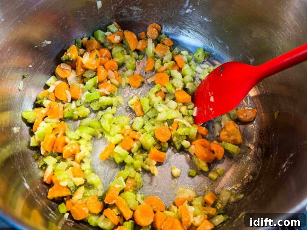 Adding flour to the softened vegetables to create a roux.
