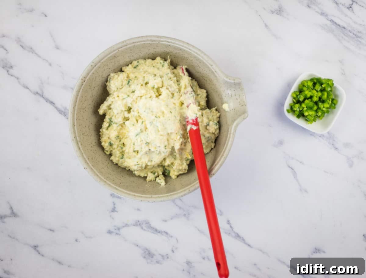 Creamy Jalapeno Artichoke Dream 8 A bowl of the prepared dip base with finely diced jalapenos waiting to be stirred in, showcasing the final step before serving.