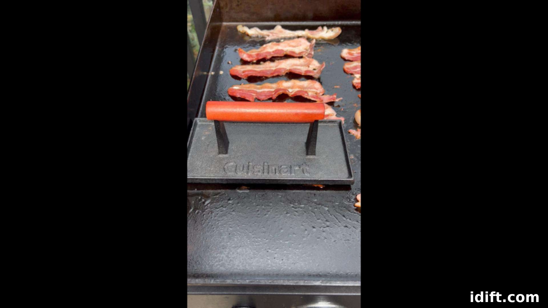 Blackstone Bacon Mastery: Achieve Crispy Perfection 9 A bacon press being used to keep curling bacon strips flat on the griddle for uniform crispiness.