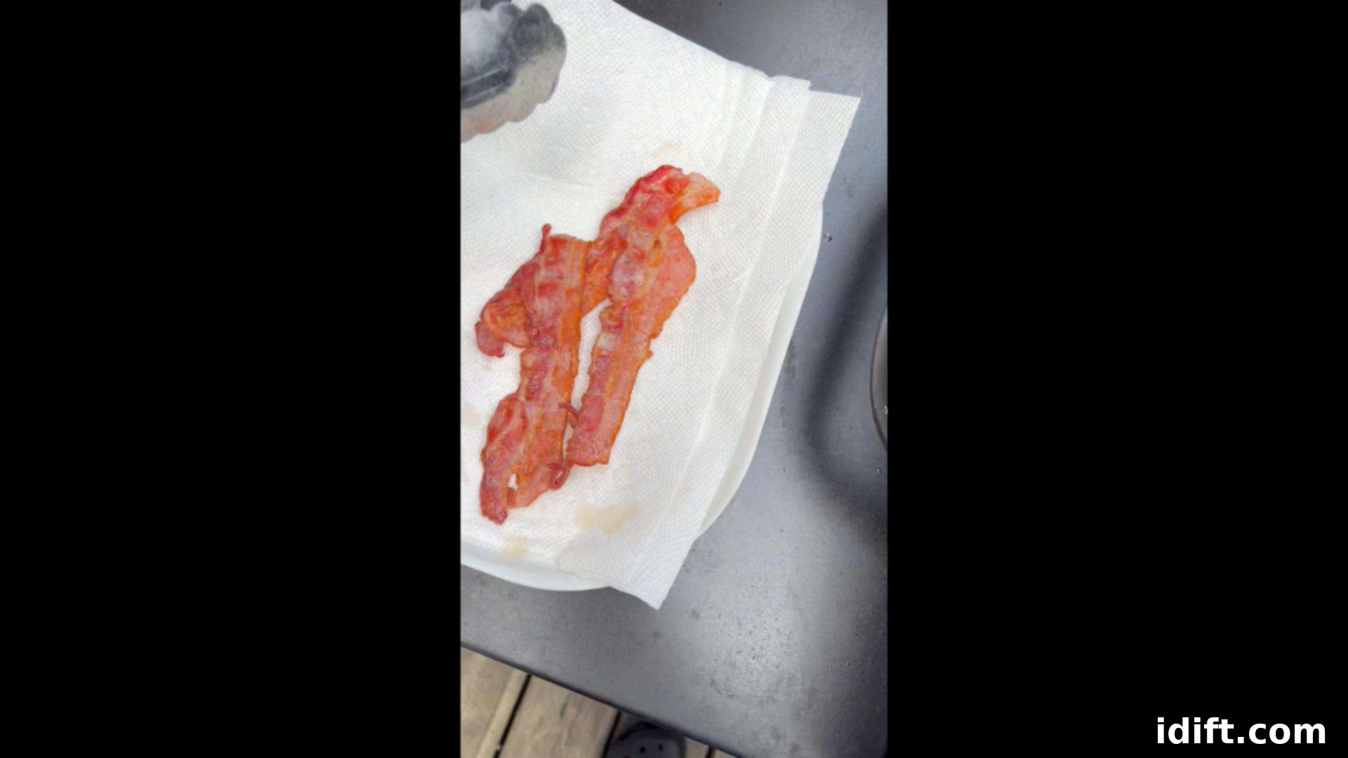 Blackstone Bacon Mastery: Achieve Crispy Perfection 10 Cooked, crispy bacon being drained on paper towels to remove excess grease before serving.