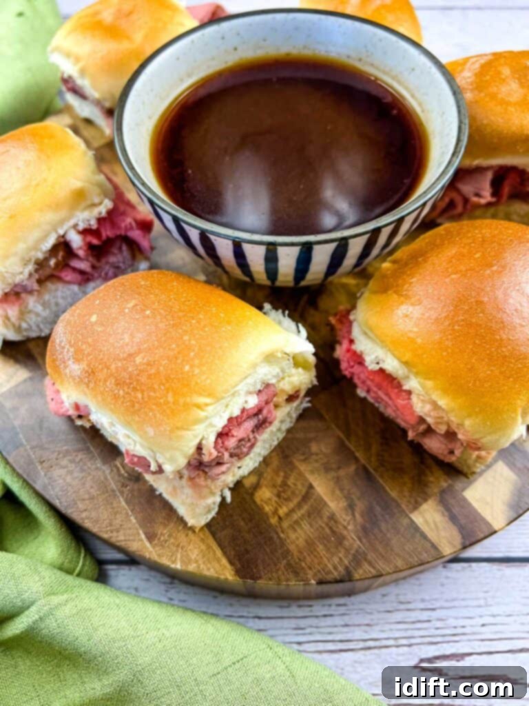 Smoked French Dip Sliders on a cutting board with jus in the middle.