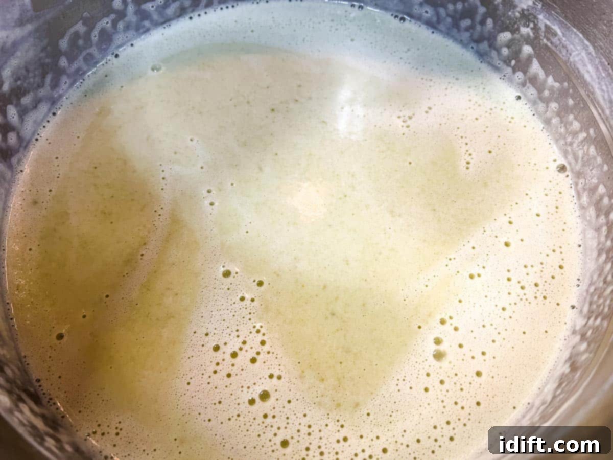 Jalapeno Velvet Warmth 10 The soup gently simmering in the pot with heavy whipping cream added, achieving a rich, creamy consistency.