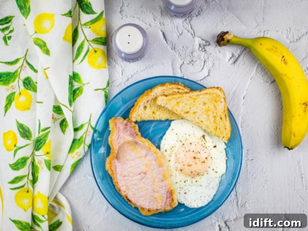 peameal bacon on a blue plate with toast and eggs.
