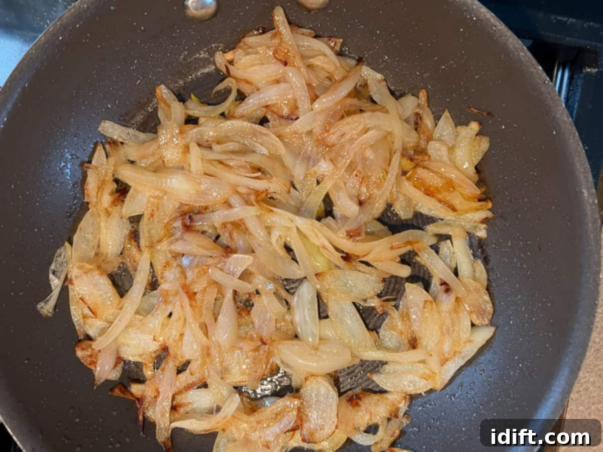 Sweet Caramelized Onion and Umami Mushroom Soup 8 Beautifully caramelized onions, a rich golden-brown hue, glistening in a skillet after a patient cooking process.