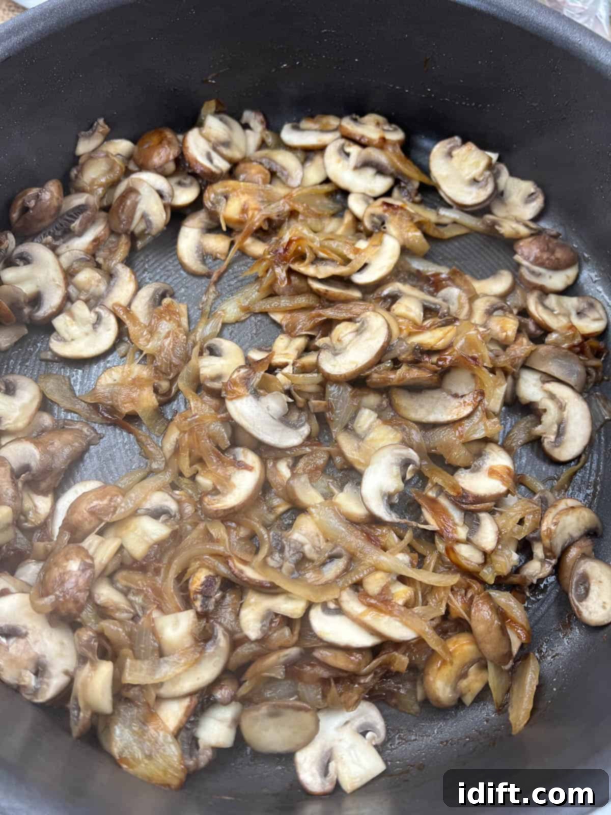 Sweet Caramelized Onion and Umami Mushroom Soup 9 Sliced mushrooms cooking in a skillet alongside the caramelized onions, softening and releasing their natural liquids, before garlic and wine are added.