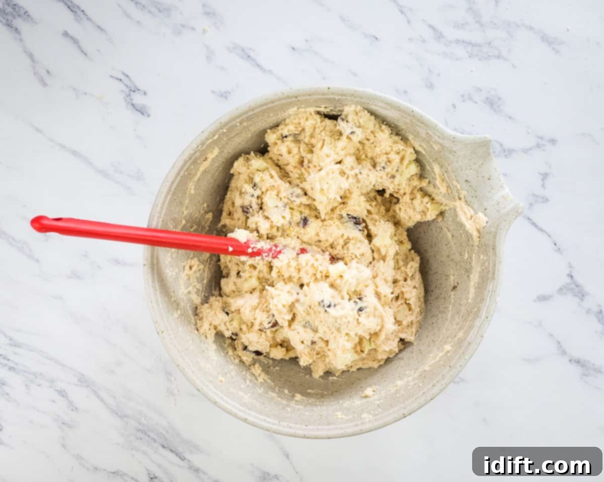 Wholesome Apple Date Walnut Muffins 10 The wet and dry ingredients, with apples, dates, and walnuts, are gently combined into a lumpy muffin batter.