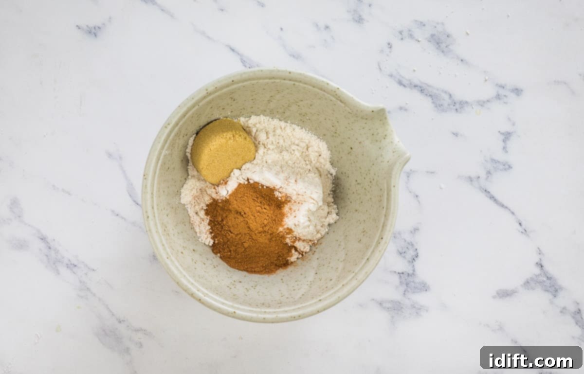 Wholesome Apple Date Walnut Muffins 12 Topping ingredients mixed in a small bowl, ready to be sprinkled over uncooked muffins.