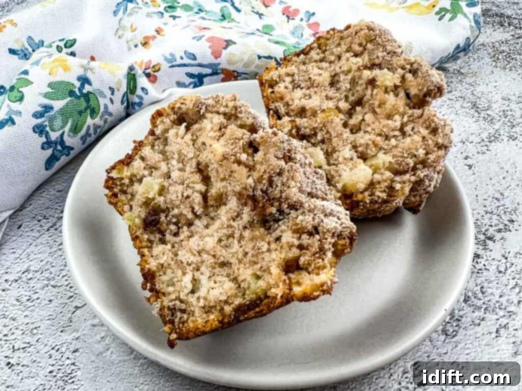 Wholesome Apple Date Walnut Muffins 3 A perfectly sliced Apple, Date, and Walnut Muffin on a white plate, revealing its moist interior with visible chunks of apple, dates, and walnuts.