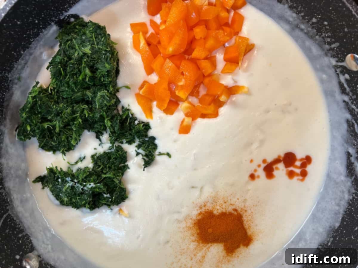 Spinach, peppers, and spices added to the cream sauce base.