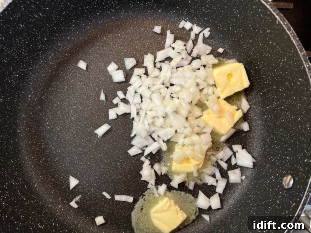 Sauteing the onions in the butter in a skillet.
