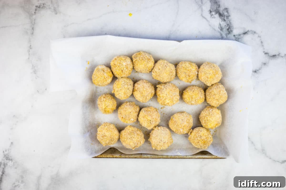 Savory Kraut Poppers 13 Rolled and breaded sauerkraut balls on a small sheet pan.