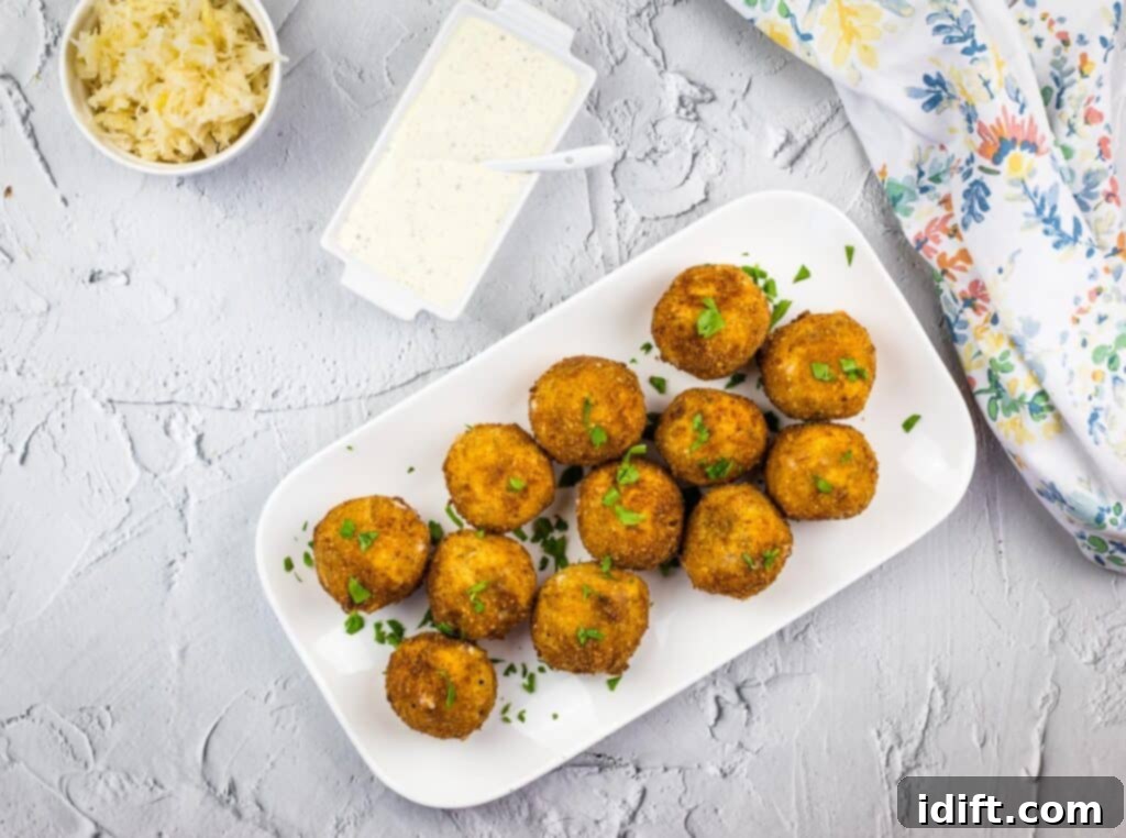 Savory Kraut Poppers 6 A top-down shot of Sauerkraut Balls with dipping sauce in a smaller dish.