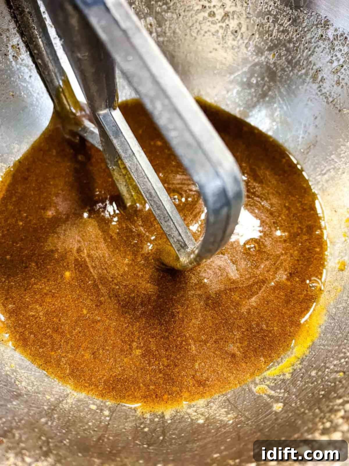 Brown butter and eggs being mixed in a stand mixer.