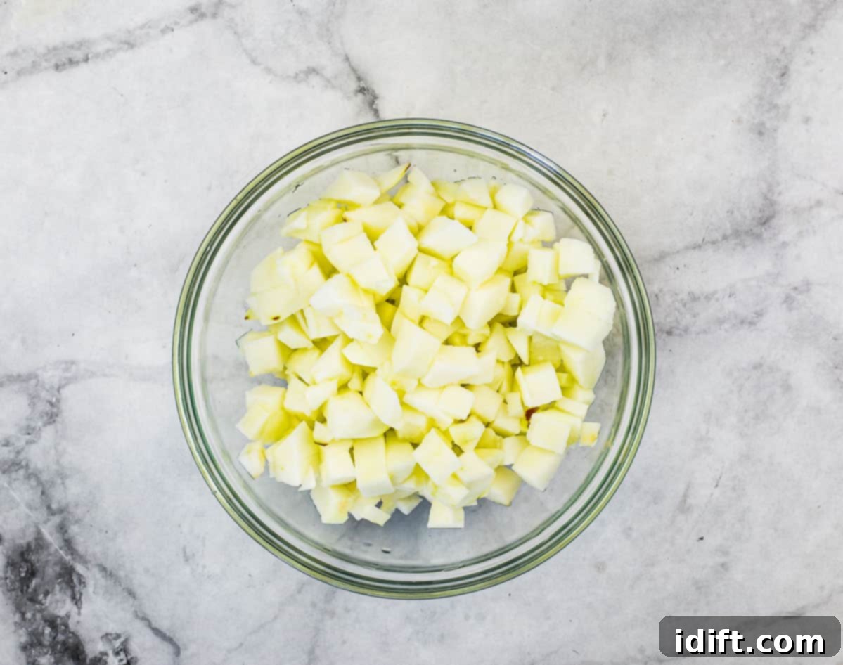 A bowl of uniformly diced apples, prepped for the recipe.