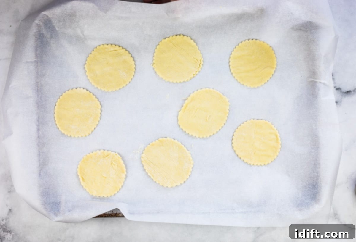 Perfectly cut puff pastry rounds arranged on a baking sheet lined with parchment paper, awaiting their delicious filling.