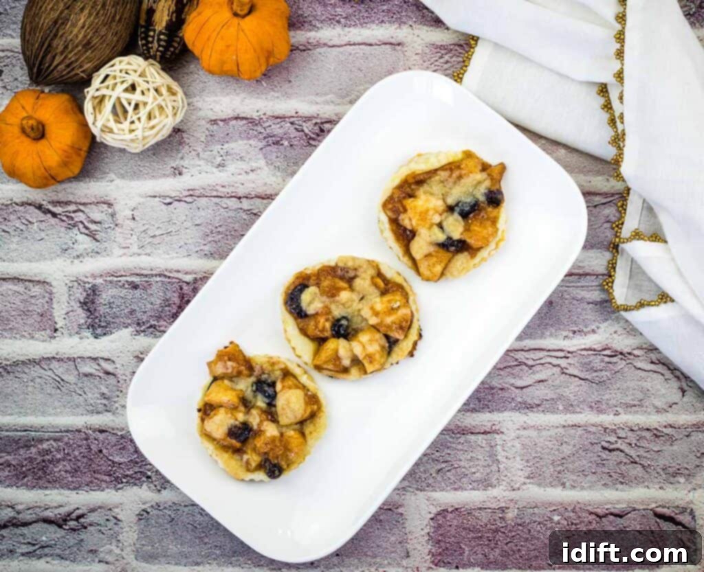 A stunning arrangement of freshly baked apple cranberry tarts on a elegant white platter, highlighting their rustic charm and golden-brown crusts.