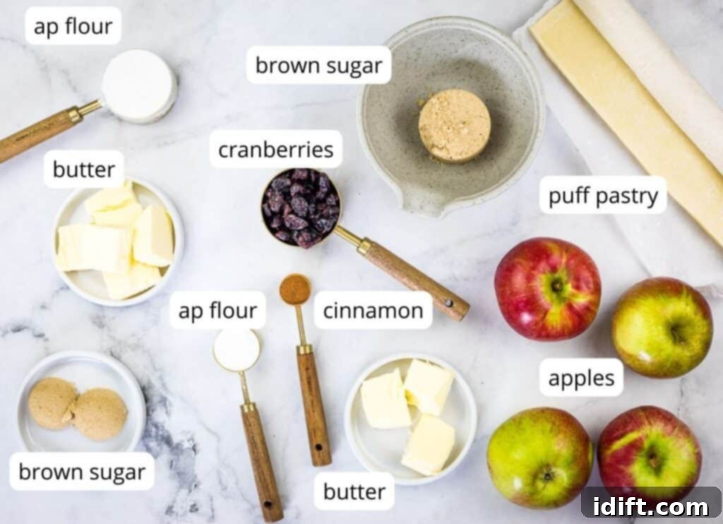 Clearly labeled fresh ingredients laid out on a clean countertop, ready to be transformed into delicious apple-cranberry puff pastry tarts.