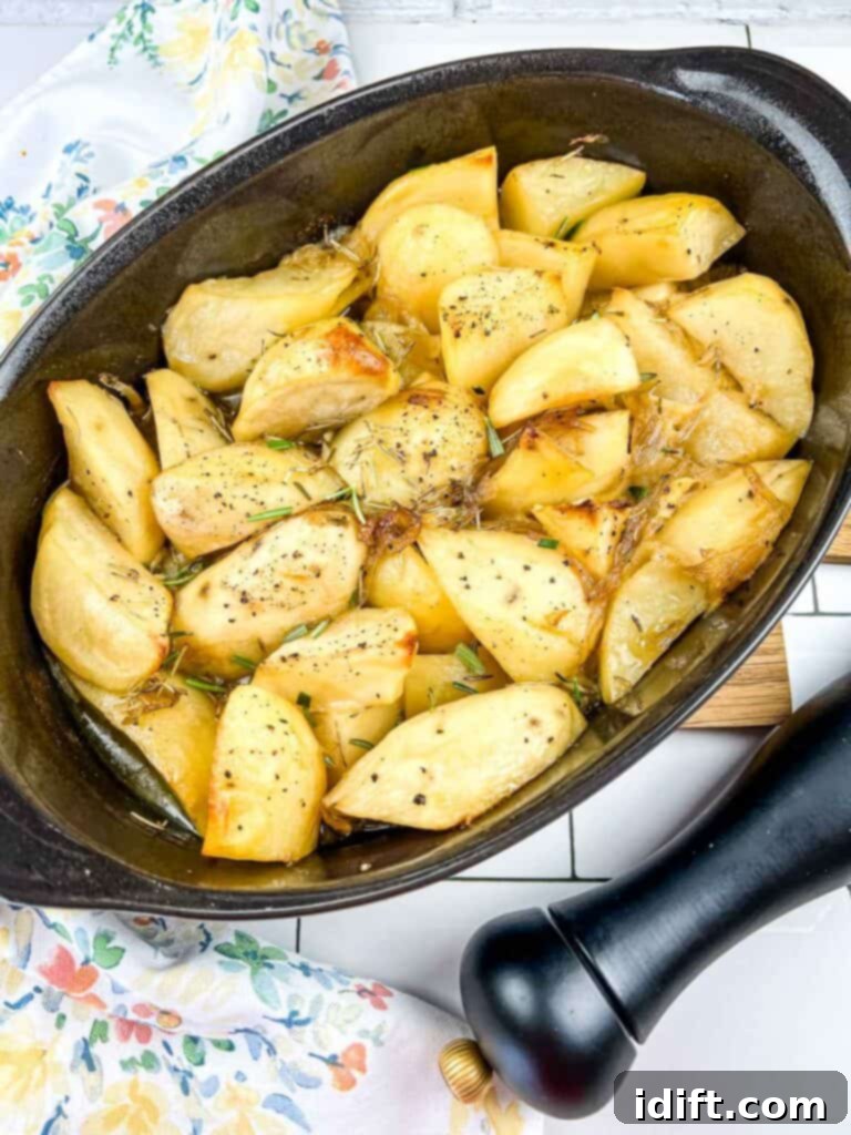 Rustic Rosemary Garlic Potato Braise 2 Golden brown garlic and rosemary braised potatoes served in a rustic casserole dish, ready to be enjoyed.