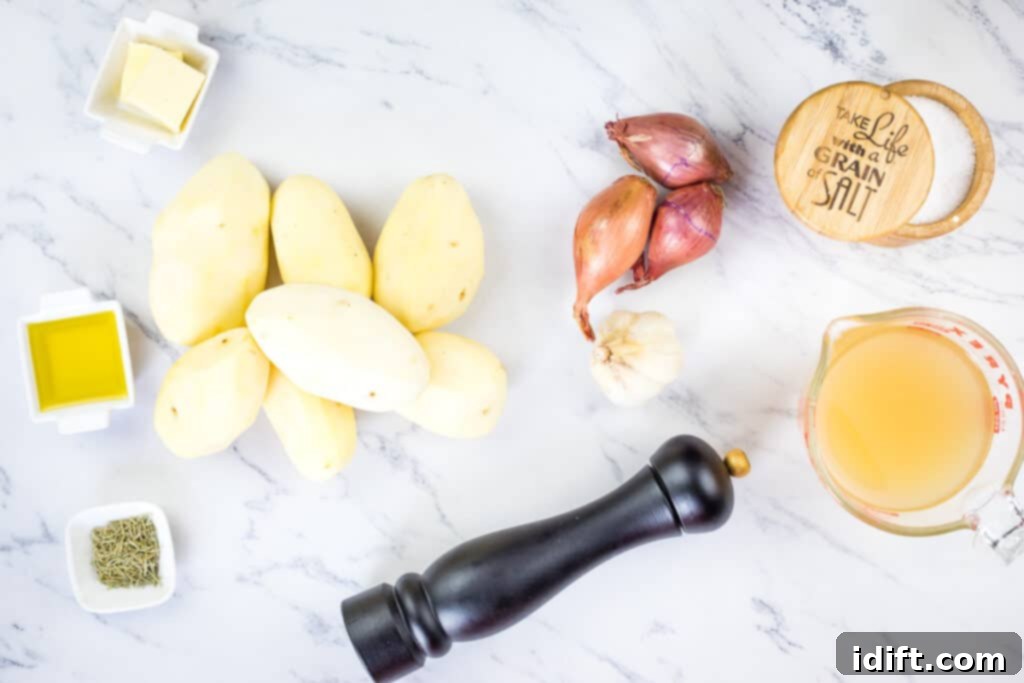 Rustic Rosemary Garlic Potato Braise 5 Ingredients laid out for garlic and rosemary braised potatoes: whole potatoes, fresh garlic, shallots, dried rosemary, olive oil, butter, and chicken broth.