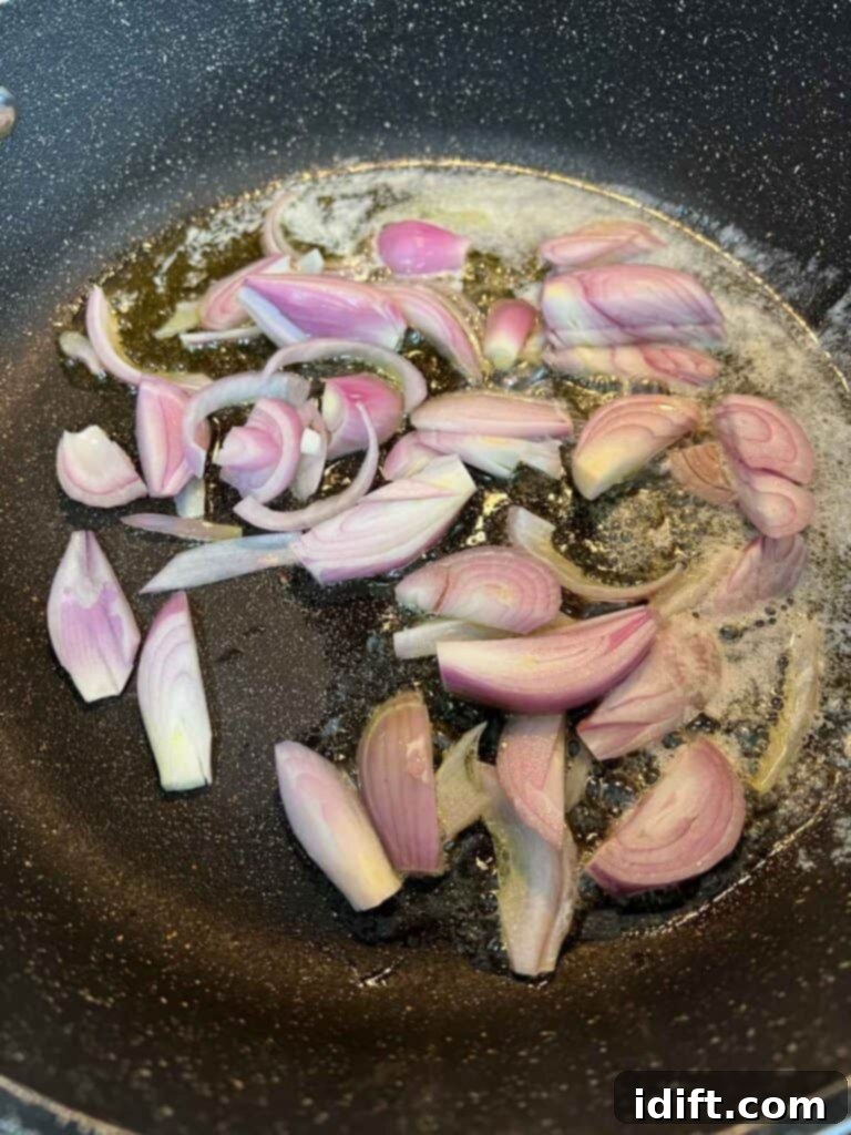 Rustic Rosemary Garlic Potato Braise 6 Shallots being sautéed in a skillet with butter and olive oil until softened.