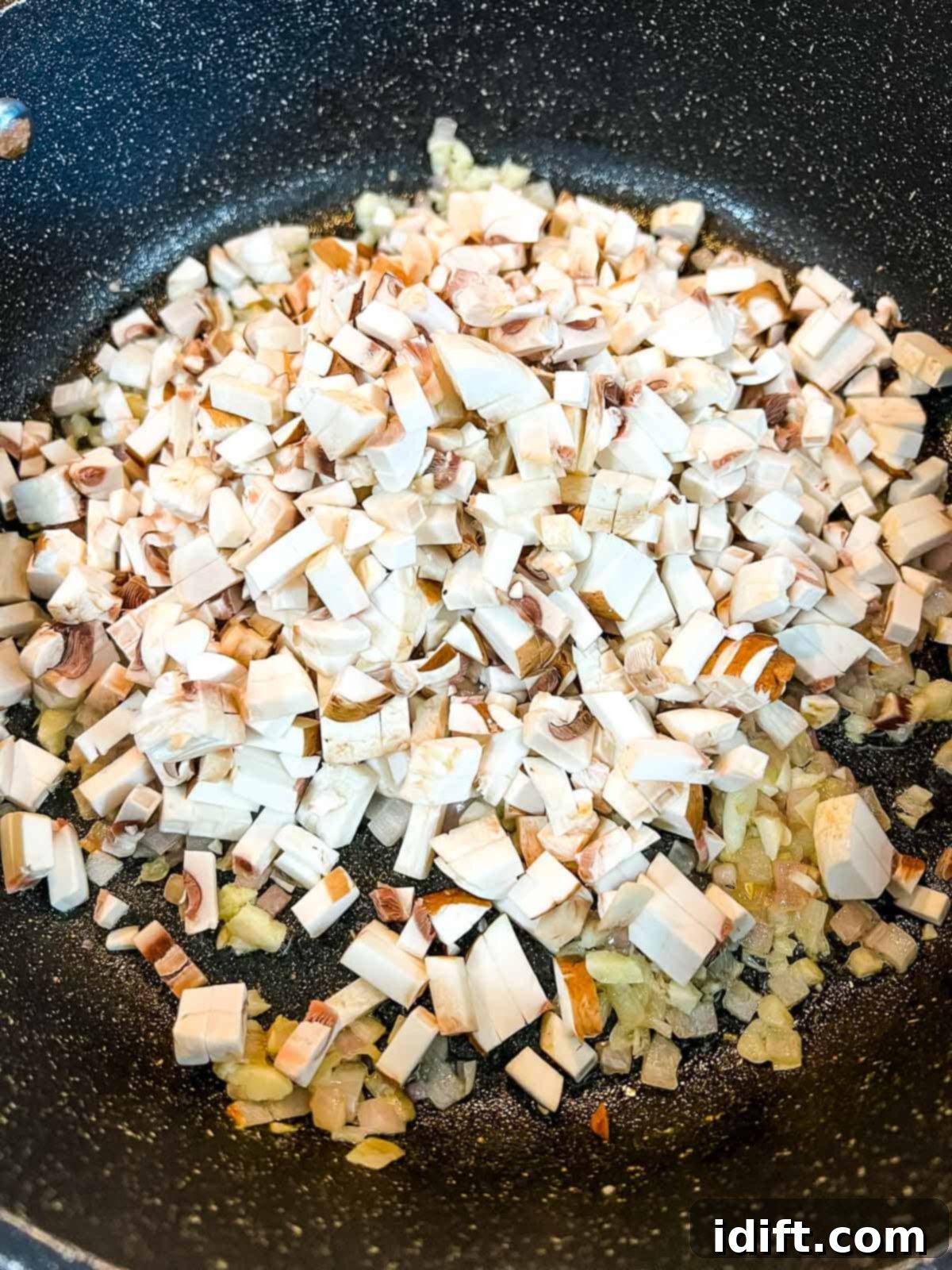 Adding the finely chopped mushrooms to the shallots.