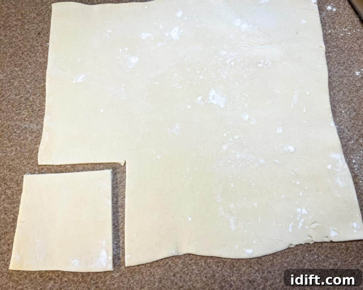 Rolled puff pastry with a square cut out of it.