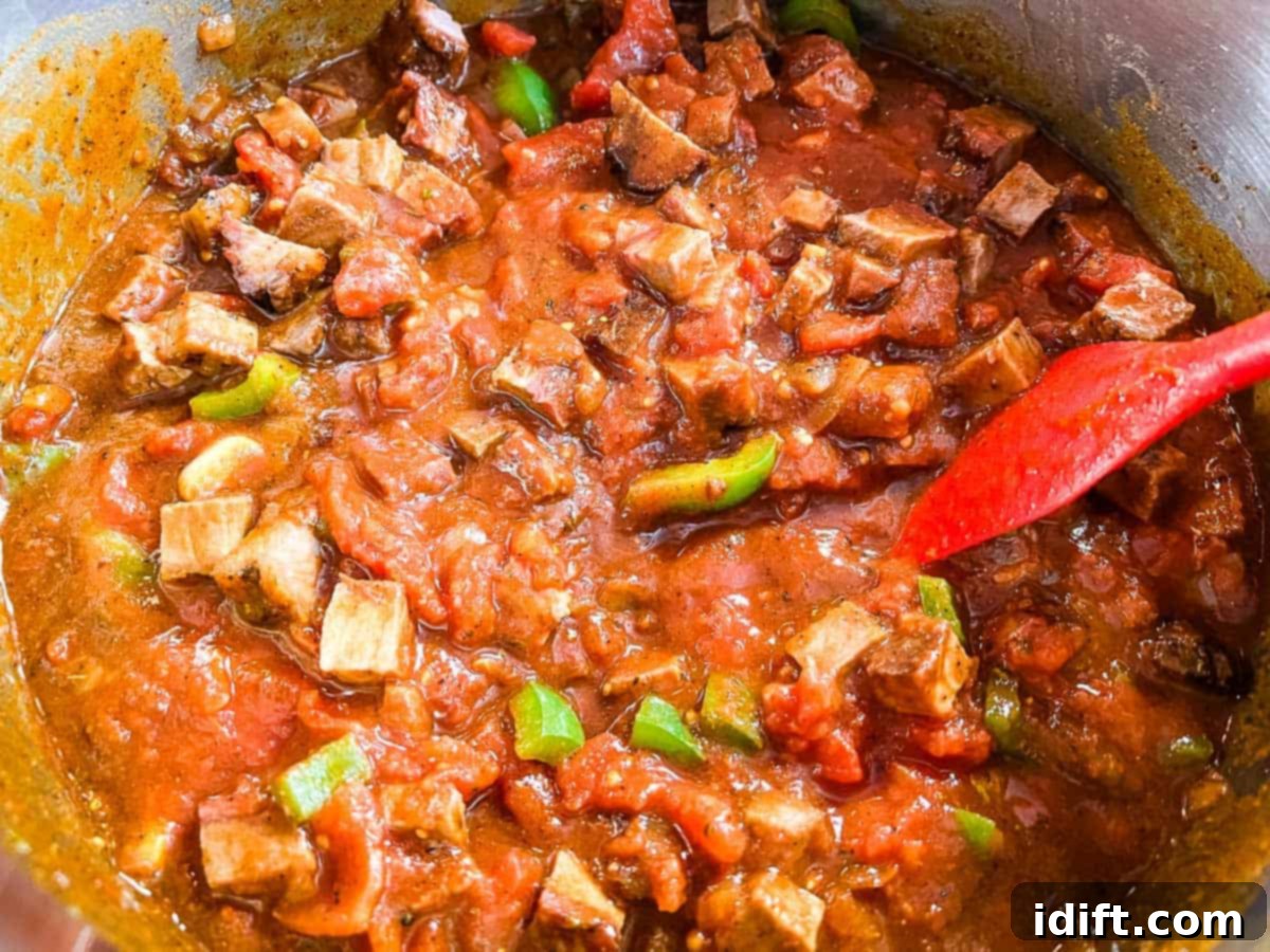 Broth, tomatoes, beer, and brisket added to the pot.