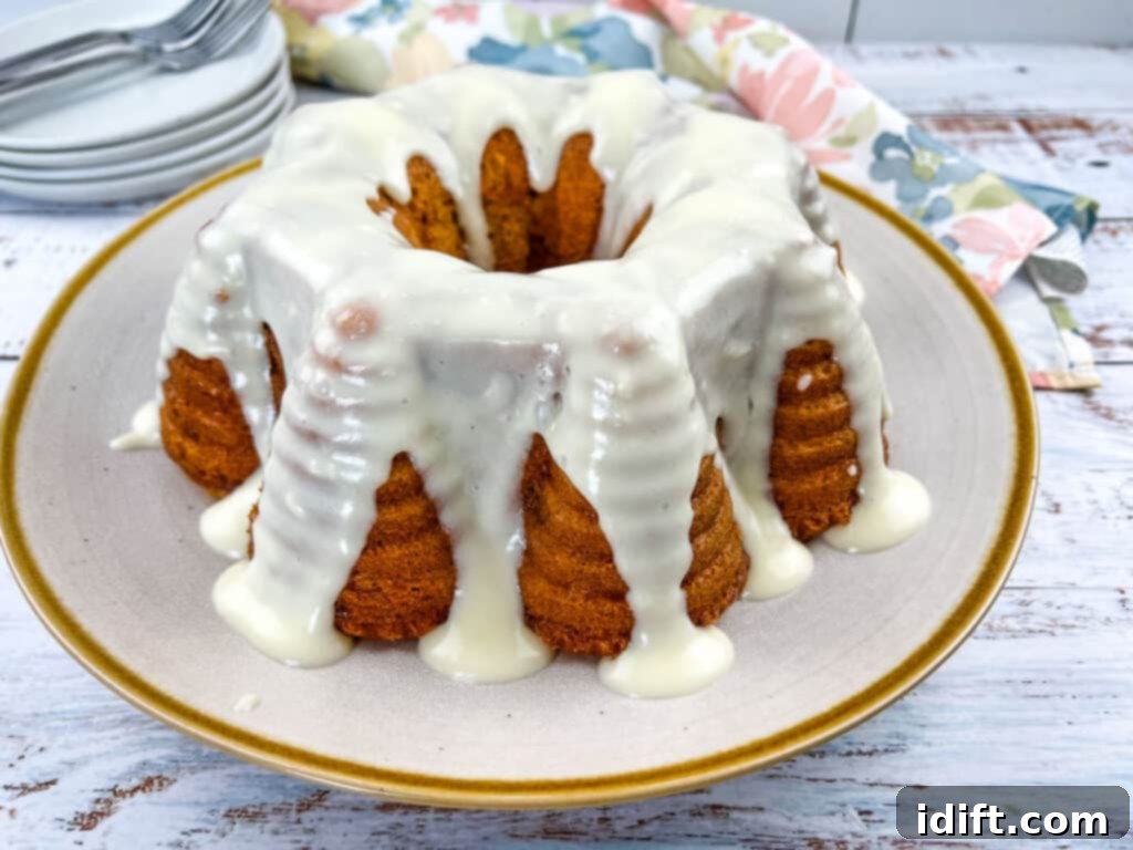 A whole Buttermilk Banana Cake with Cream Cheese Glaze on a large plate.