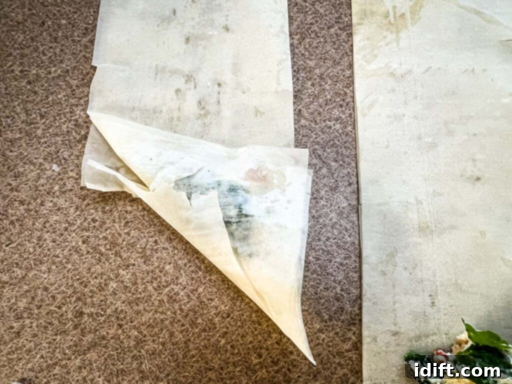 The bottom left corner of the phyllo folded over to create a triangle.