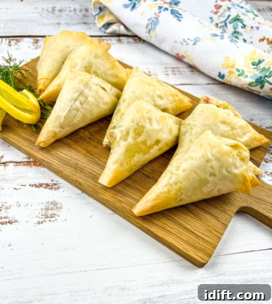 Crab spanakopita on a wooden board.