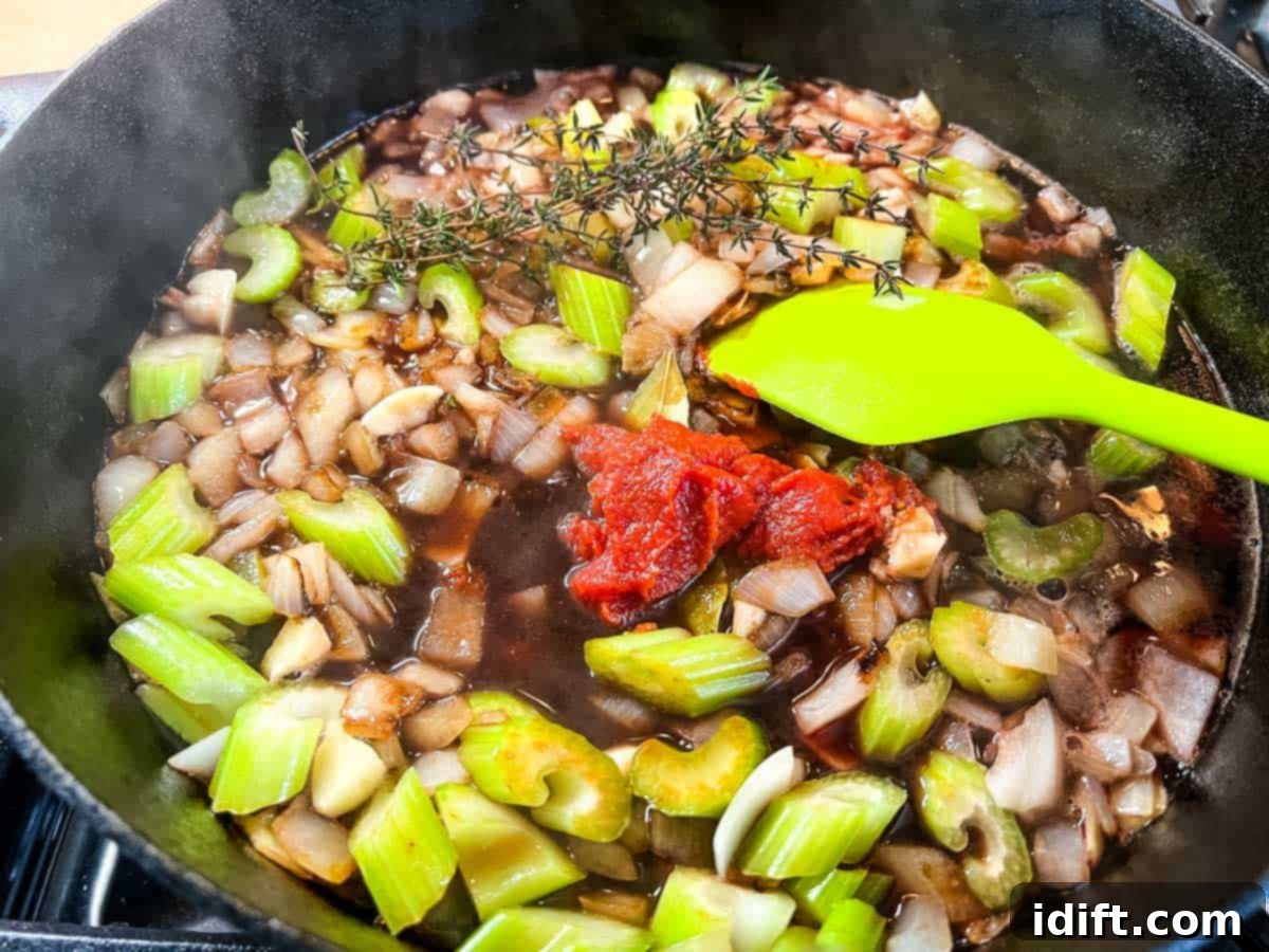 Hearty Smokehouse Beef Stew 9 A pan with deglazed vegetables, enriched with tomato paste and fresh herbs, ready to be combined with the smoked beef.