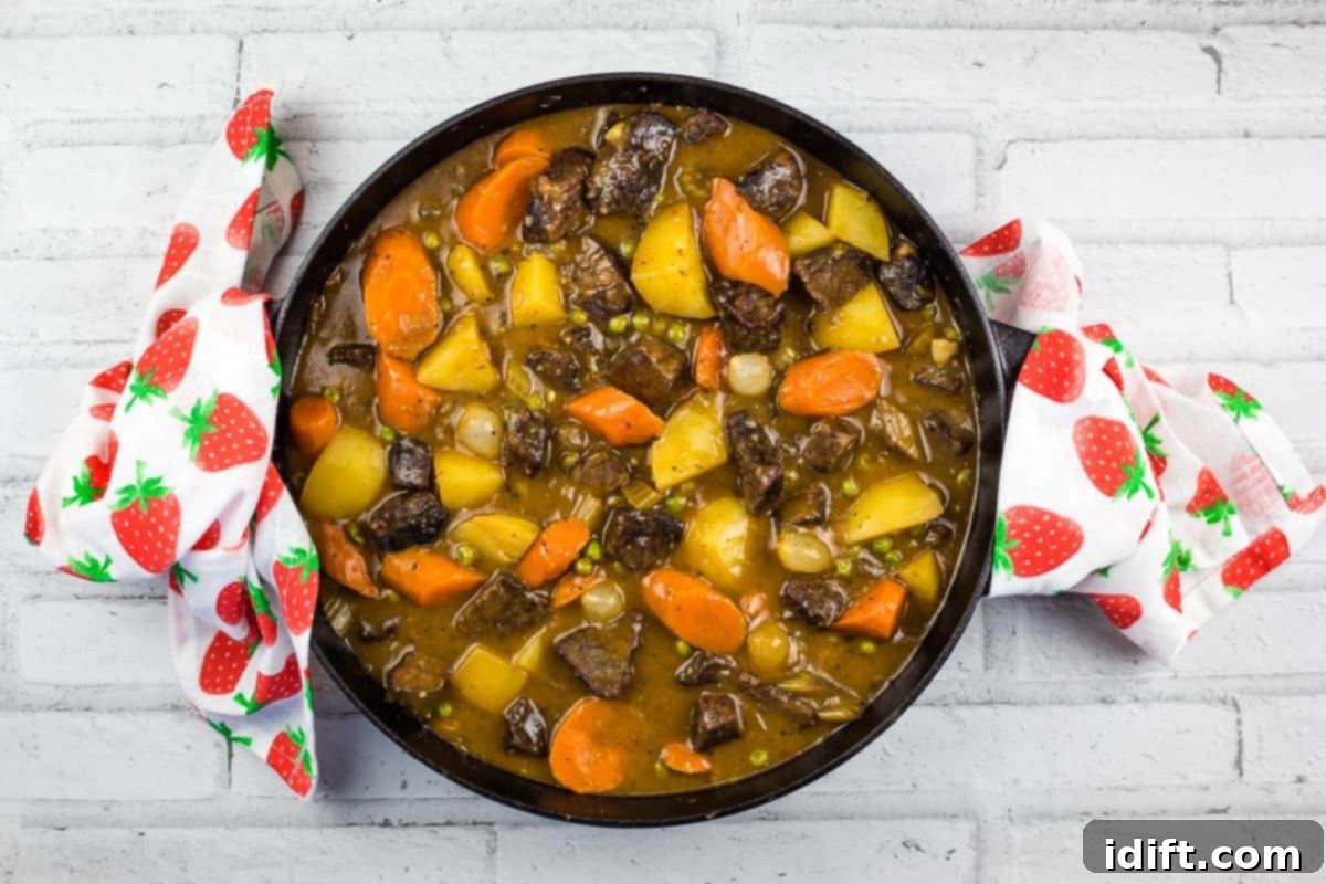 Hearty Smokehouse Beef Stew 11 A bubbling black cast iron dish filled with deeply flavored Smoked Beef Stew, fresh off the smoker, ready to be served.