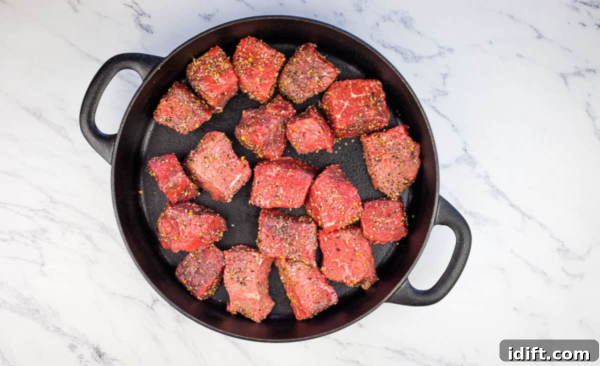 Hearty Smokehouse Beef Stew 7 Beef cubes generously seasoned with salt and pepper, arranged on a tray, ready to be placed in the smoker for their initial smoky infusion.