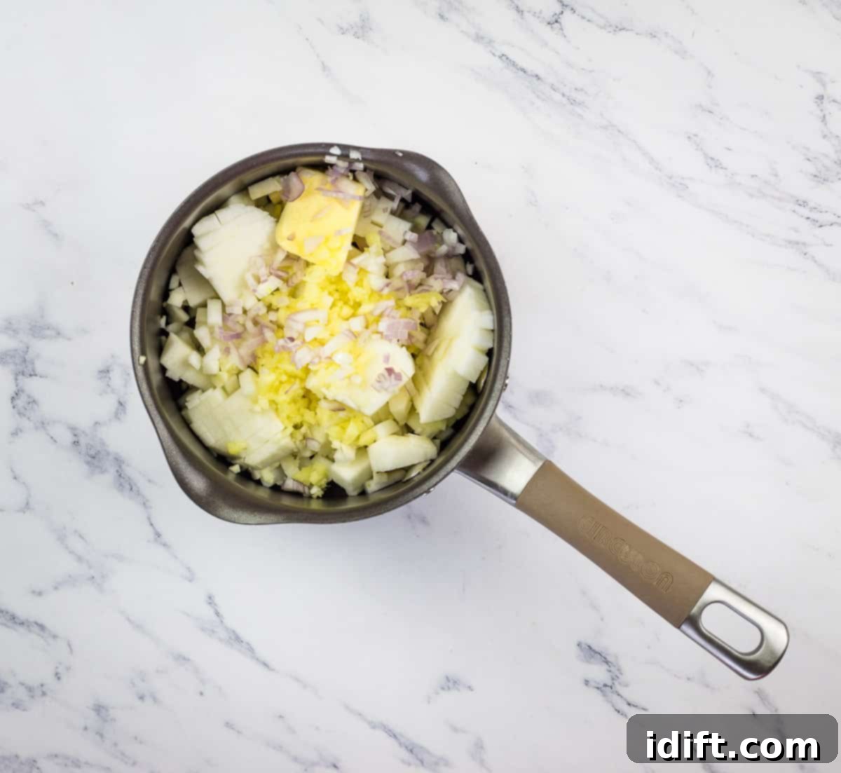 The initial chutney ingredients, including diced apples, shallots, ginger, and garlic, gently sautéing in a small saucepan.