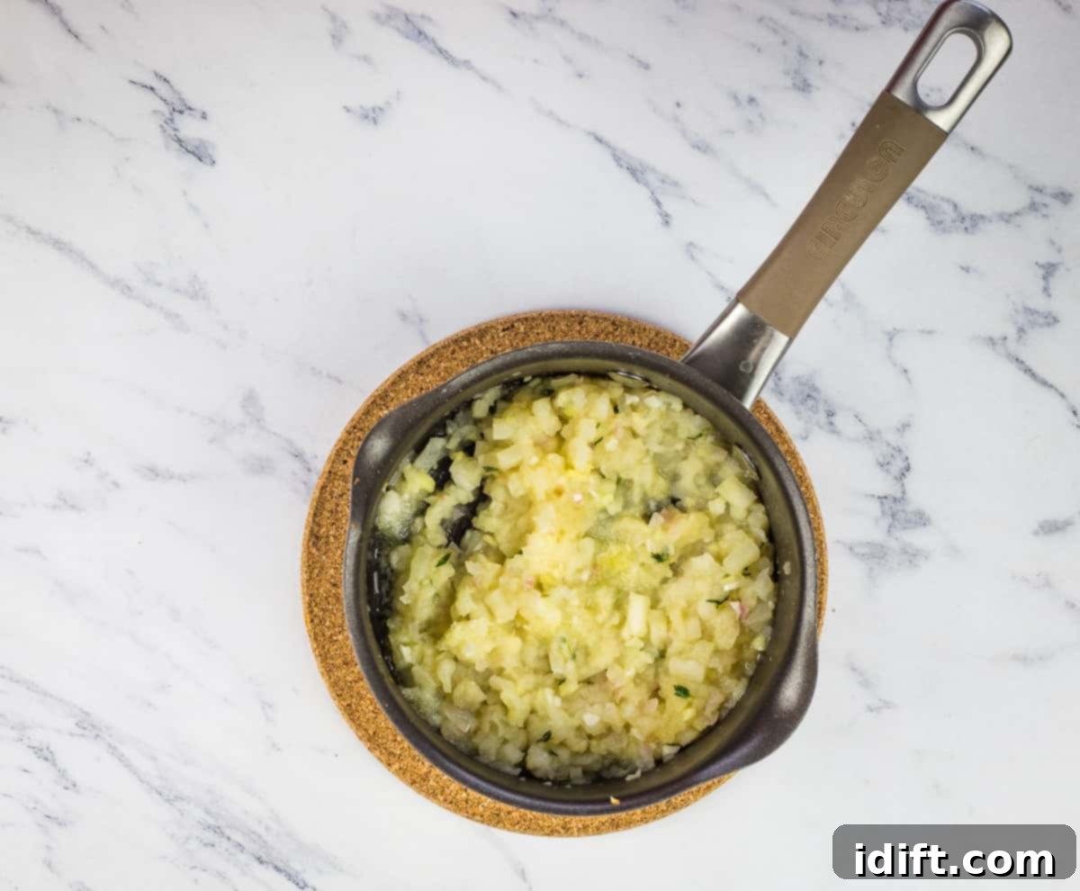 The apple ginger chutney, having cooked down to a tender consistency, waiting for final seasoning adjustments in the pan.